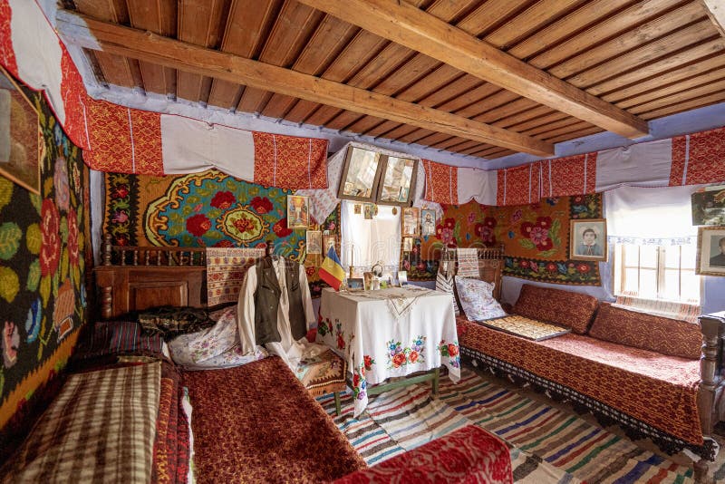 Corbi, Romania - July 2019: traditional peasants house interior well preserved with authentic carpets, clothing and personal items