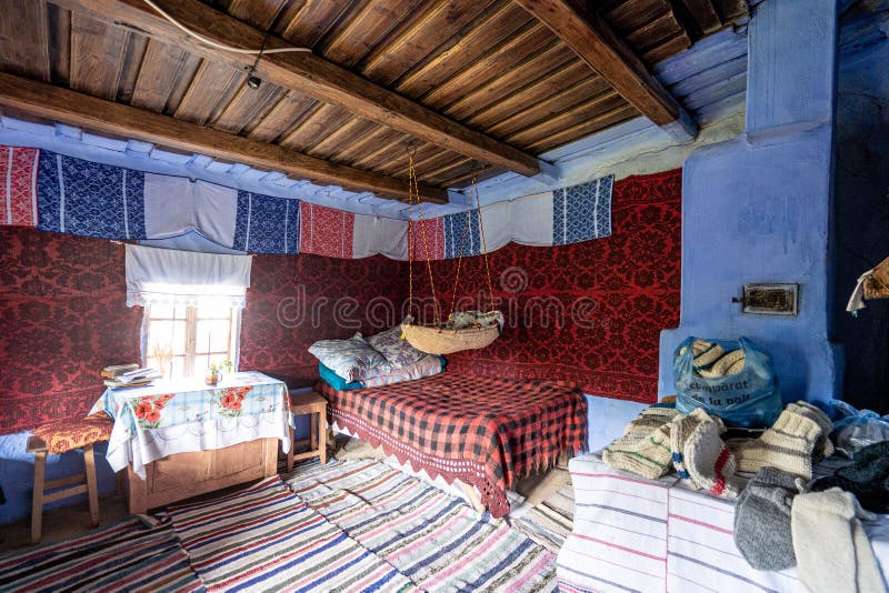 Corbi, Romania - July 2019: traditional peasants house interior well preserved with authentic carpets, clothing and personal items