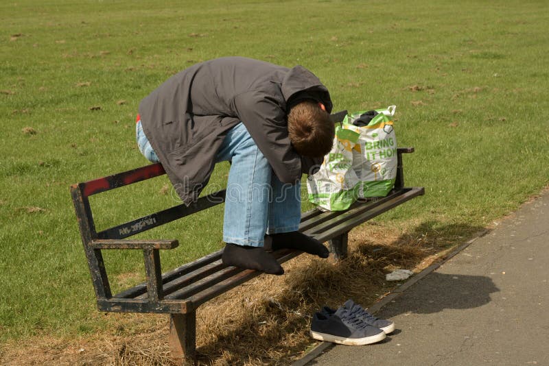 Corby, U k , Le 20 juin 2019 - homme sans abri dormant sur un banc dehors image stock Corby, U k , Le 20 juin 2019 - homme sans abri dormant sur un banc dehors image stock