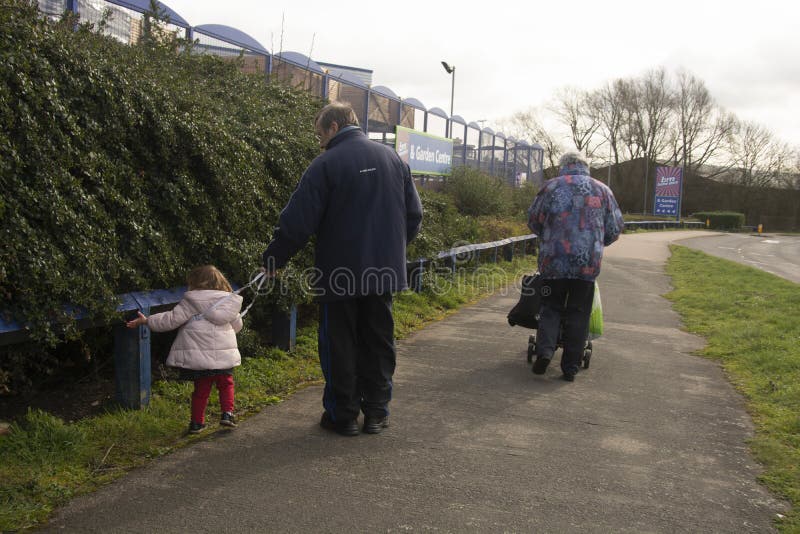 Corby, U K, le 19 mars 2019 - grands-parents marchant avec leur neveu de fille, s'amusant et x27 ; société de s Couples de pensio image stock Corby, U K, le 19 mars 2019 - grands-parents marchant avec leur neveu de fille, s'amusant et x27 ; société de s Couples de pensio image stock
