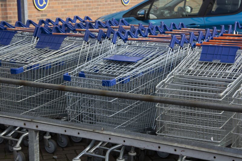 Corby, U K, o 19 de março de 2019 - uma fileira longa de carros dos troles da compra na loja de LIDL, fora de um grande supermerc imagem de stock royalty free Corby, U K, o 19 de março de 2019 - uma fileira longa de carros dos troles da compra na loja de LIDL, fora de um grande supermerc imagem de stock royalty free