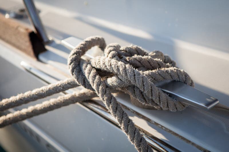Corda bianca di attracco legata intorno all'ancora d'acciaio sulla barca o sulla nave immagine stock Corda bianca di attracco legata intorno all'ancora d'acciaio sulla barca o sulla nave immagine stock