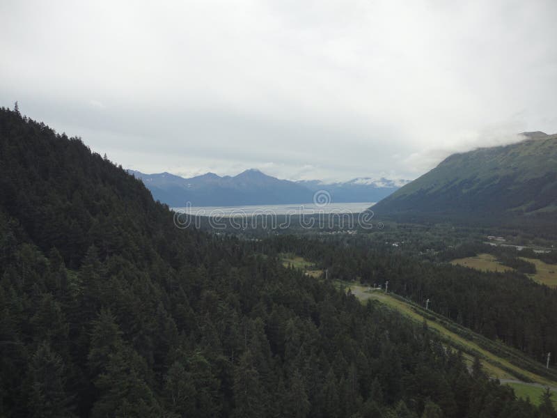 Cordillera con los bosques y la corriente Selva tropical templada enorme en Alaska con las nubes y el sol fotografía de archivo Cordillera con los bosques y la corriente Selva tropical templada enorme en Alaska con las nubes y el sol fotografía de archivo