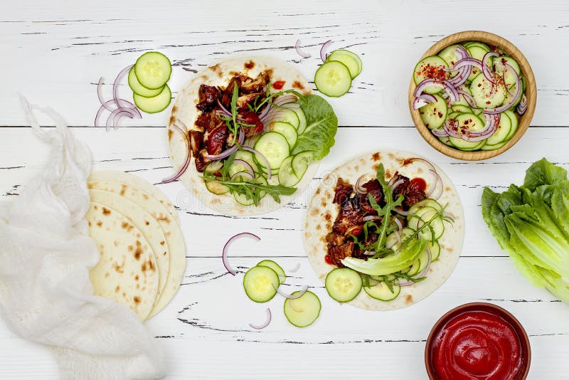 Coreano reduzca los tacos cocinados de la carne de vaca con el slaw del pepino y la salsa de tomate asiáticos del sriracha Visión fotos de archivo libres de regalías Coreano reduzca los tacos cocinados de la carne de vaca con el slaw del pepino y la salsa de tomate asiáticos del sriracha Visión fotos de archivo libres de regalías
