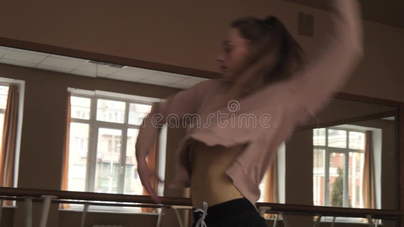 Coreógrafo de sexo femenino flexible joven que practica elementos contemporáneos de la danza en el estudio en la cámara lenta