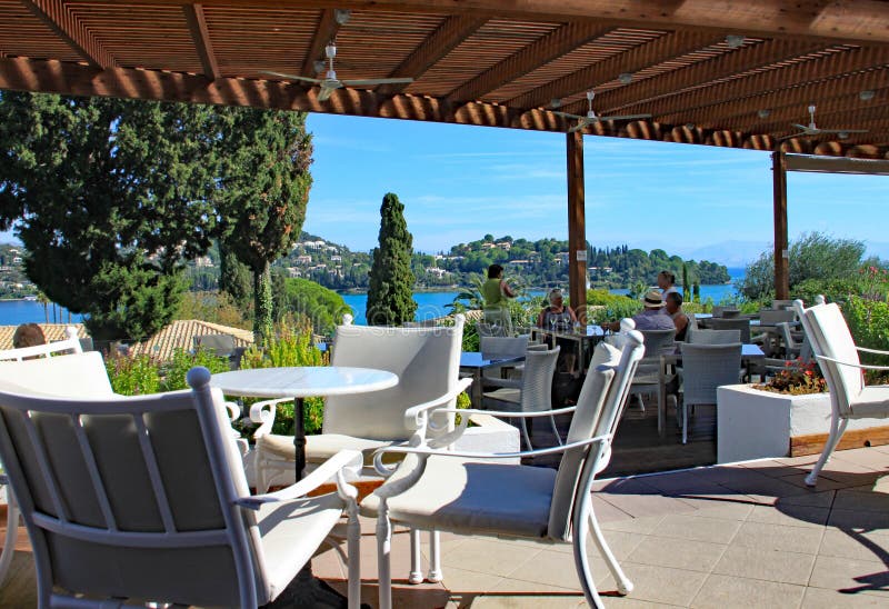CORFU, GRÉCIA - 5 DE OUTUBRO DE 2012: Área coberta da barra do hotel do feriado com vista maravilhosa sobre o mar próximo foto de stock CORFU, GRÉCIA - 5 DE OUTUBRO DE 2012: Área coberta da barra do hotel do feriado com vista maravilhosa sobre o mar próximo foto de stock