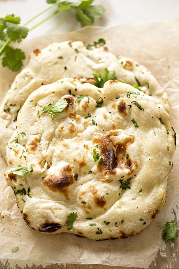 Coriander naan bread on wooden board