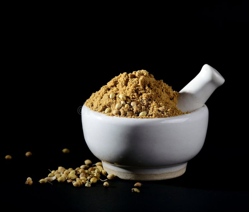 Coriander Powder and Coriander Seeds on Black Background Stock Image