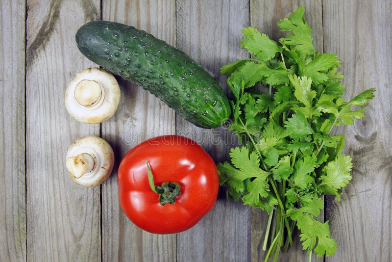 Coriander, Tomato, Mushrooms and Cucumber on Wooden Surface Stock Photo