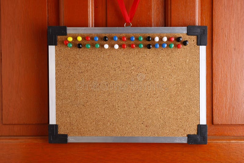 Cork board with colorful push pins hanging by a door royalty free stock image Cork board with colorful push pins hanging by a door royalty free stock image