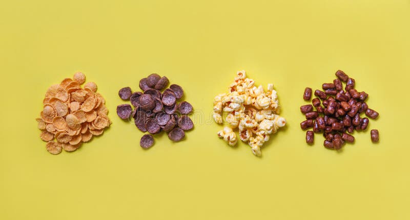 Corn-Flakes Imbiss der verschiedenen Getreidearten und Popcornstapel auf Draufsicht des gelben Hintergrundes zum Frühstück lizenzfreie stockfotos Corn-Flakes Imbiss der verschiedenen Getreidearten und Popcornstapel auf Draufsicht des gelben Hintergrundes zum Frühstück lizenzfreie stockfotos