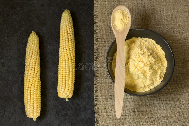 Corn Grits in a Bowl and a Wooden Spoon on a Dark Background. Fresh