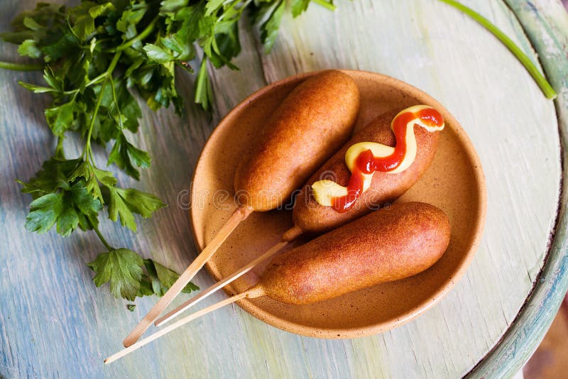 Corndog med senap, ketchup och persilja arkivbild Corndog med senap, ketchup och persilja arkivbild