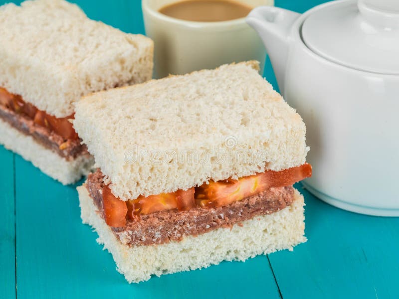 Corned Beef and Tomato White Bread Sandwich With a Pot of Hot Tea