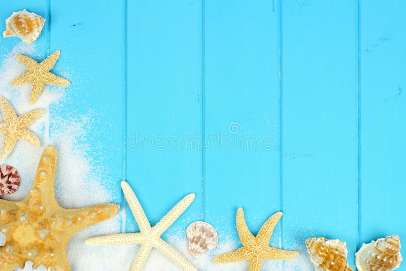 Corner border of sand, seashells and starfish on blue wood royalty free stock photos Corner border of sand, seashells and starfish on blue wood royalty free stock photos