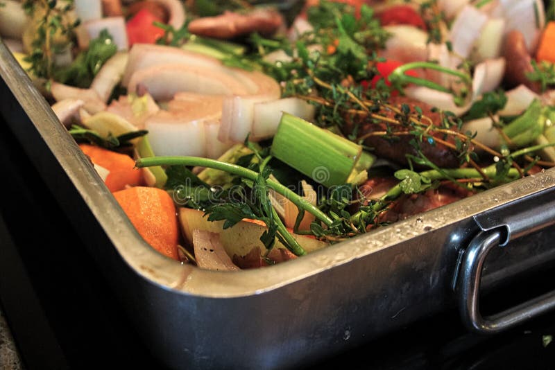 A Roasting Pan Full of Vegetables and Herbs Steaming Stock Photo