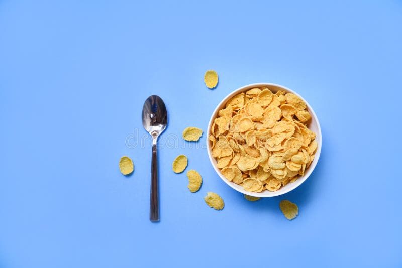 Cornflakes in Bowl on Blue Background Spoon for Cereal Healthy Food