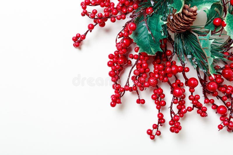 Corona di Natale delle bacche e del sempreverde dell'agrifoglio isolati su fondo bianco