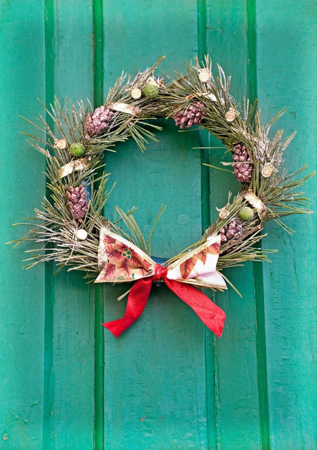 Corona di natale su un portello verde. fotografia stock libera da diritti Corona di natale su un portello verde. fotografia stock libera da diritti