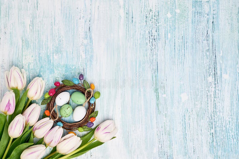 Corona di Pasqua, tulipani bianchi ed uova di Pasqua decorative su fondo blu-chiaro Vista superiore fotografie stock libere da diritti Corona di Pasqua, tulipani bianchi ed uova di Pasqua decorative su fondo blu-chiaro Vista superiore fotografie stock libere da diritti