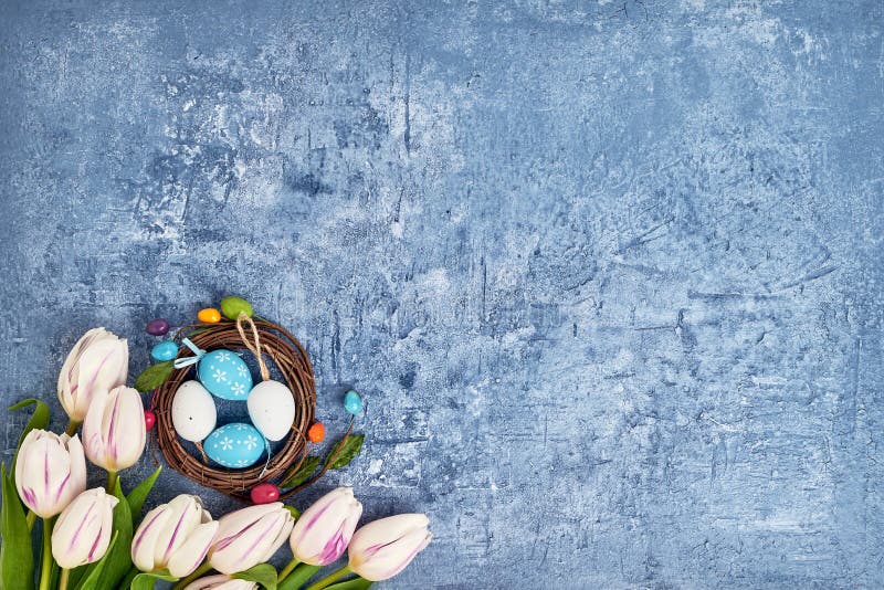 Corona di Pasqua, tulipani bianchi ed uova di Pasqua decorative su fondo blu Vista superiore fotografia stock libera da diritti Corona di Pasqua, tulipani bianchi ed uova di Pasqua decorative su fondo blu Vista superiore fotografia stock libera da diritti