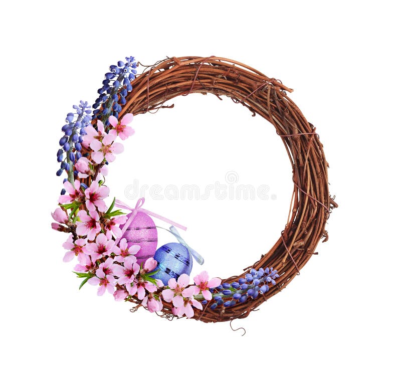 Corona di rattano marrone secco con fiori rosa e blu di primavera uova di Pasqua e nastro di satina isolati su bianco immagine stock