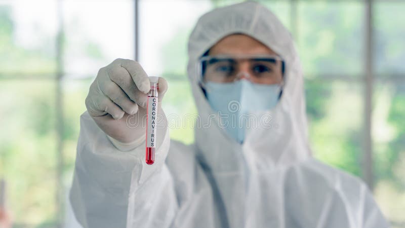Coronavirus covid- 19 amostra de sangue infectada no tubo de amostra em mãos de cientistas com vestuário de proteção contra risco fotografia de stock Coronavirus covid- 19 amostra de sangue infectada no tubo de amostra em mãos de cientistas com vestuário de proteção contra risco fotografia de stock