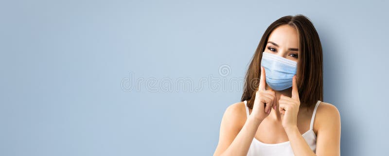 Coronavirus, covid-19, pandemic, protective concept - brunette happy smiling woman wearing showing face protection medical mask, over grey color background. Copy space blank area for some sign or text. Coronavirus, covid-19, pandemic, protective concept - brunette happy smiling woman wearing showing face protection medical mask, over grey color background. Copy space blank area for some sign or text
