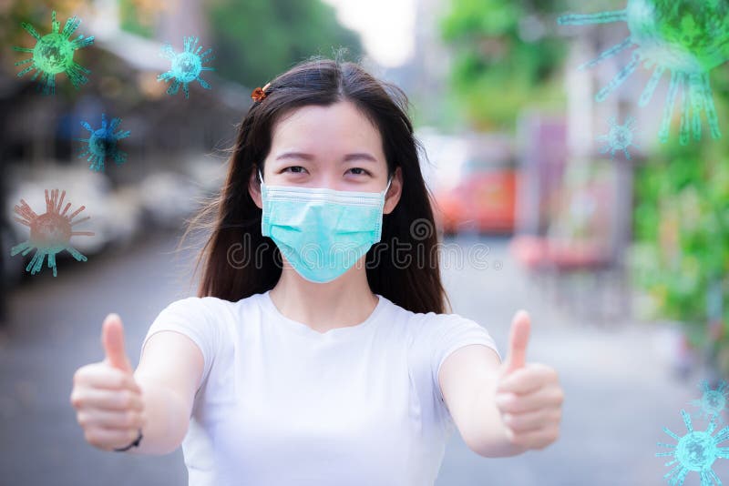 Coronavirus Covid-19 pm2.5. Work at home. Young woman wearing medical face mask show thumbs up for good and happy at home. Coronavirus disease. Stay home. Social distancing. New normal behavior. Coronavirus Covid-19 pm2.5. Work at home. Young woman wearing medical face mask show thumbs up for good and happy at home. Coronavirus disease. Stay home. Social distancing. New normal behavior.