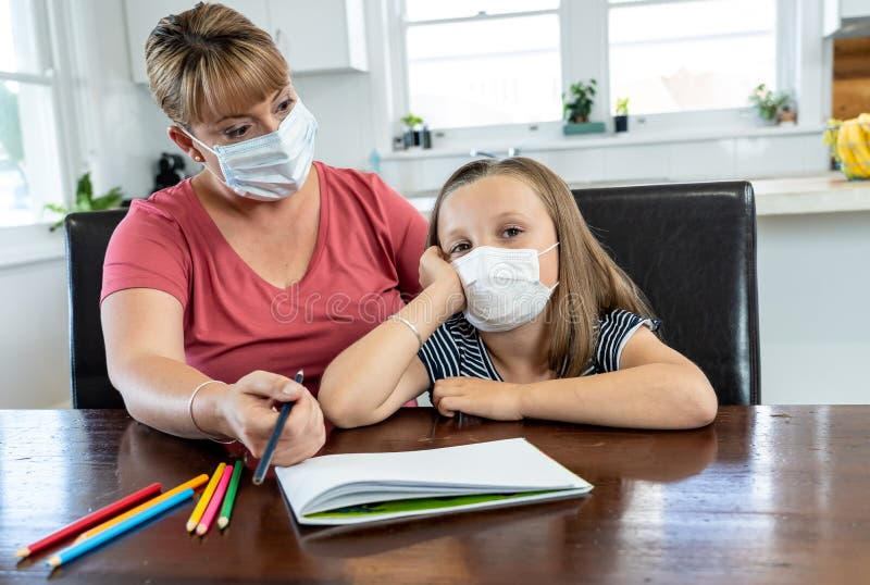 Coronavirus school closures and lockdown. Mum and bored daughter with masks studying online at home royalty free stock photos Coronavirus school closures and lockdown. Mum and bored daughter with masks studying online at home royalty free stock photos