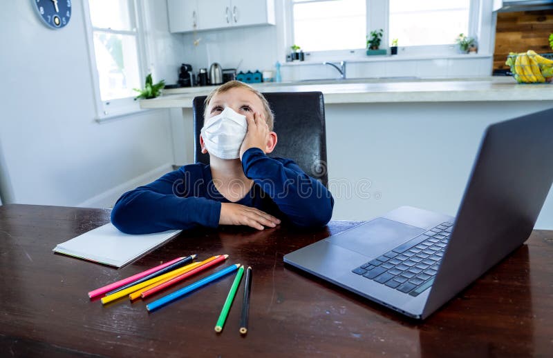 Coronavirus school closures and lockdown. Bored kid with face mask studying online class at home. Coronavirus Outbreak. Lockdown and school closures. School boy royalty free stock photos
