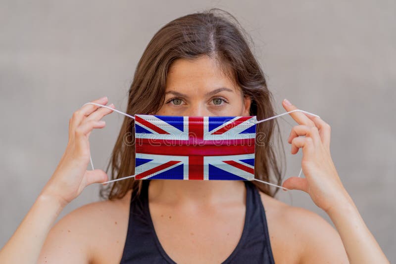 Strong portrait of young woman with UK flag face mask. COVID-19 Worldwide health crisis
