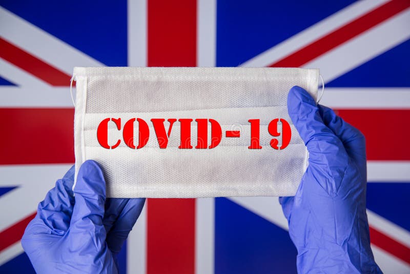 Coronavirus outbreak. Coronavirus update in Great Britain. Word Covid-19 on medical mask with UK flag on background.