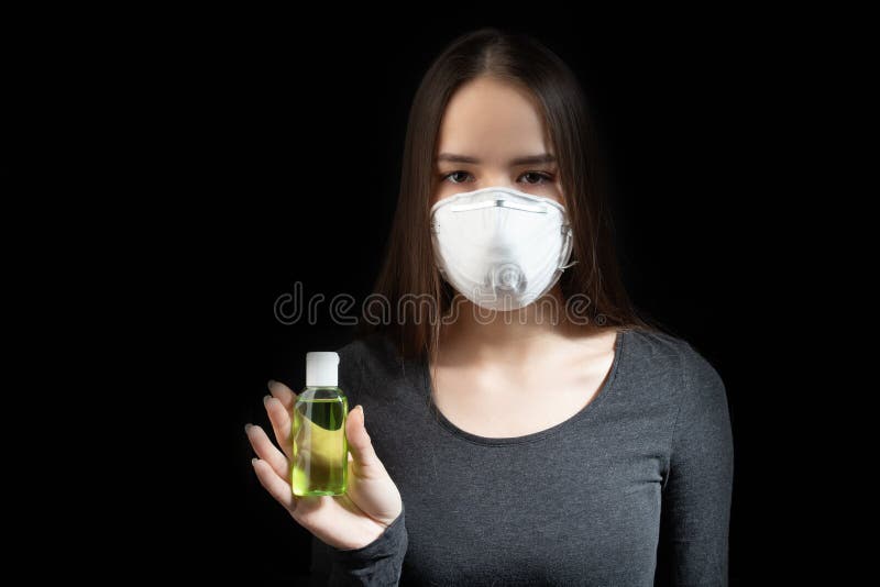 Coronavirus protection. Young woman in black antibacterial medical hand mask with antiseptic gel on a black background royalty free stock photo Coronavirus protection. Young woman in black antibacterial medical hand mask with antiseptic gel on a black background royalty free stock photo