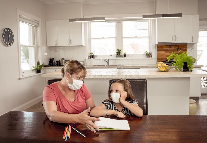 Coronavirus school closures and lockdown. Mum and bored daughter with masks studying online at home stock photos Coronavirus school closures and lockdown. Mum and bored daughter with masks studying online at home stock photos