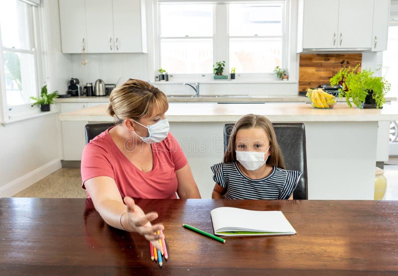 Coronavirus school closures and lockdown. Mum and bored daughter with masks studying online at home royalty free stock photography Coronavirus school closures and lockdown. Mum and bored daughter with masks studying online at home royalty free stock photography