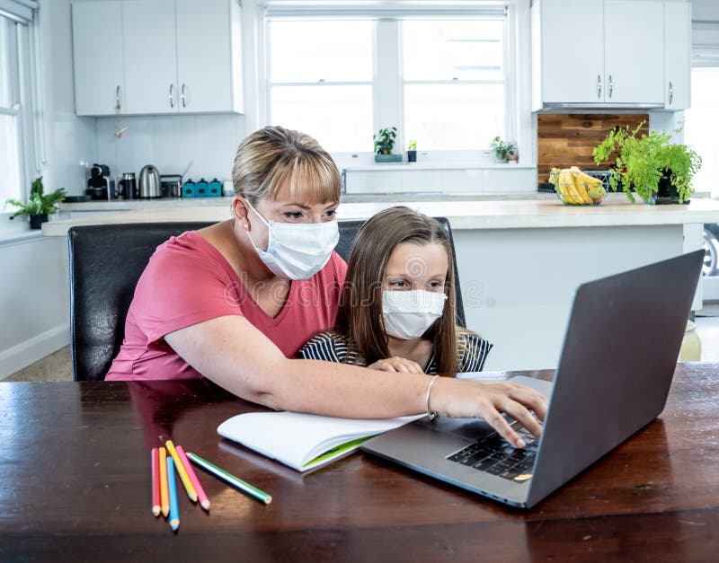 Coronavirus school closures and lockdown. Mum and bored daughter with masks studying online at home royalty free stock photos Coronavirus school closures and lockdown. Mum and bored daughter with masks studying online at home royalty free stock photos