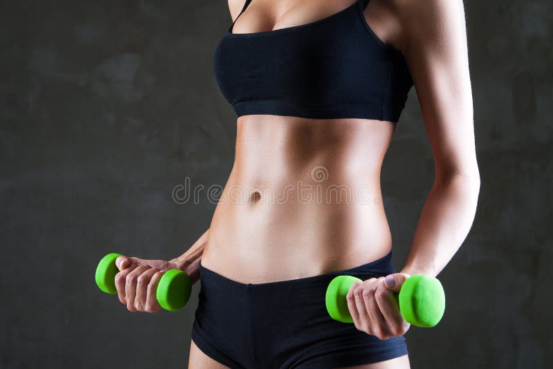 Corpo de pesos de levantamento da mulher apta dos jovens foto de stock Corpo de pesos de levantamento da mulher apta dos jovens foto de stock