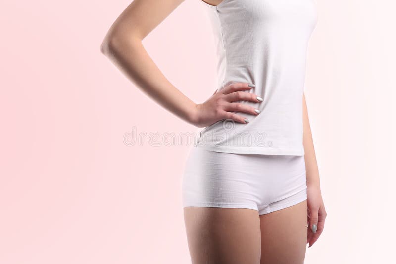 Corpo della giovane donna con le mutandine bianche e la camicia del cotone isolate sul rosa fotografie stock Corpo della giovane donna con le mutandine bianche e la camicia del cotone isolate sul rosa fotografie stock
