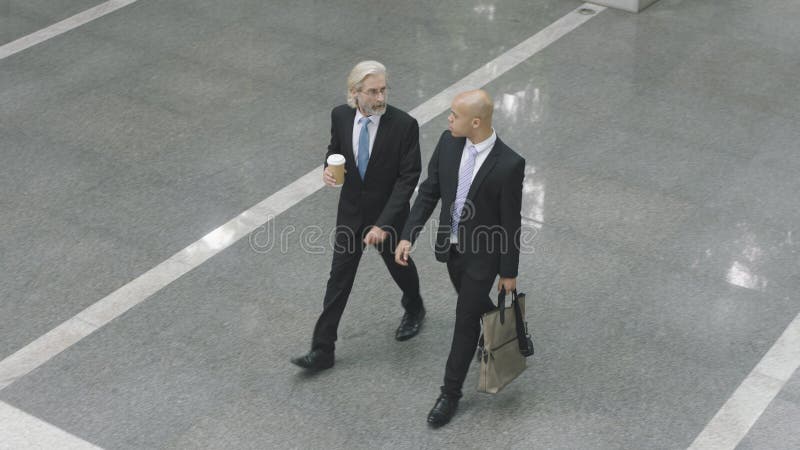 Corporate executives walking across lobby of office building royalty free stock image Corporate executives walking across lobby of office building royalty free stock image