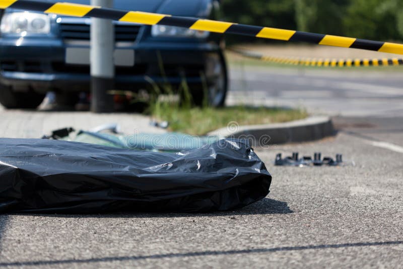 Corpse in plastic bag after car accident, horizontal