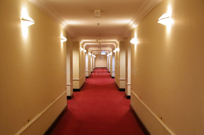 Long hotel corridor with red carpet and yellow wallpaper. Long hotel corridor with red carpet and yellow wallpaper