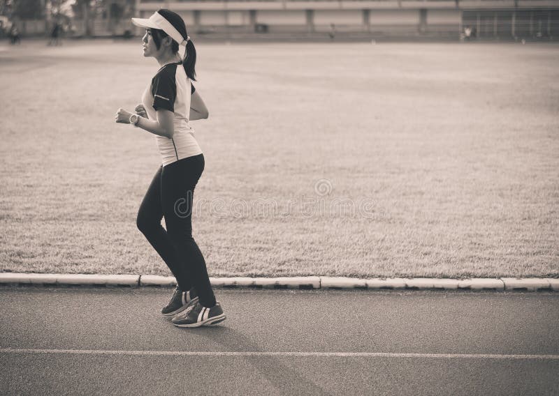 Corredor asiático hermoso joven de la mujer que corre en pista durante la puesta del sol, blanco y negro entonado imagen de archivo Corredor asiático hermoso joven de la mujer que corre en pista durante la puesta del sol, blanco y negro entonado imagen de archivo