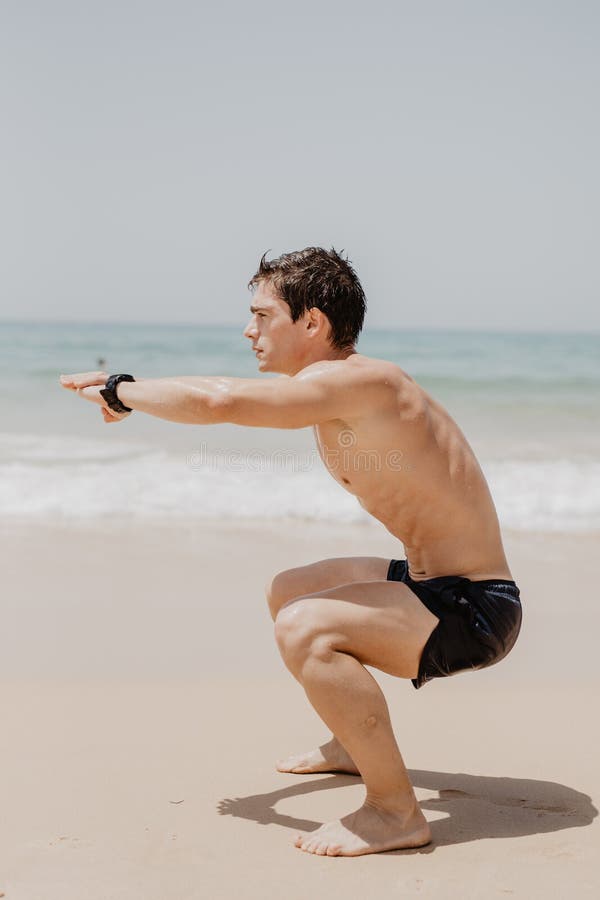 Corredor ativo do atleta que corre no Sandy Beach Equipe por muito tempo o salto no oceano, correndo com de alta energia no cardi