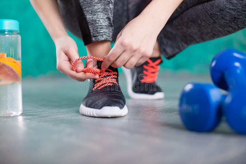Corredor de la mujer joven que ata cordones Dieta Concepto de dieta Alimento sano Hembra joven hermosa con la botella de agua imagenes de archivo Corredor de la mujer joven que ata cordones Dieta Concepto de dieta Alimento sano Hembra joven hermosa con la botella de agua imagenes de archivo