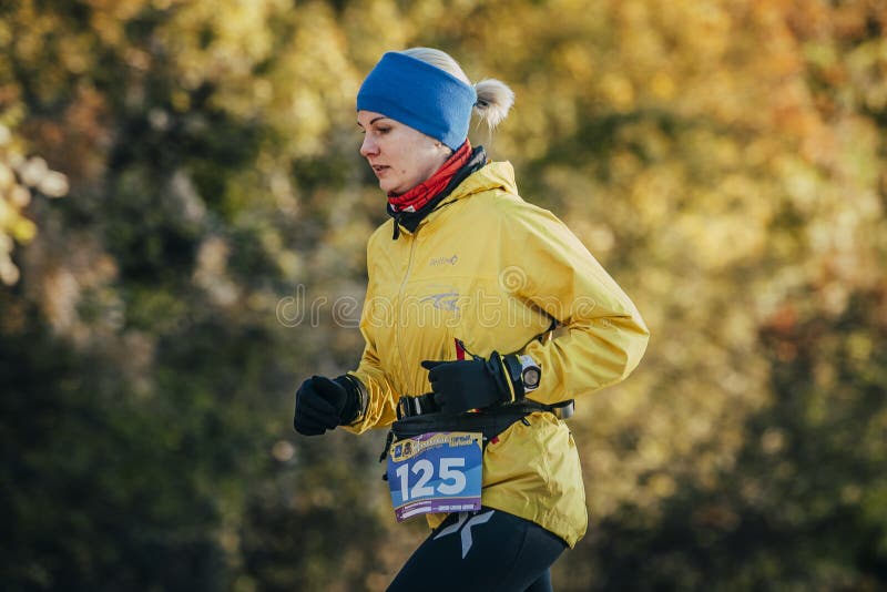 Corredor de la mujer joven que corre en bosque del otoño foto de archivo Corredor de la mujer joven que corre en bosque del otoño foto de archivo