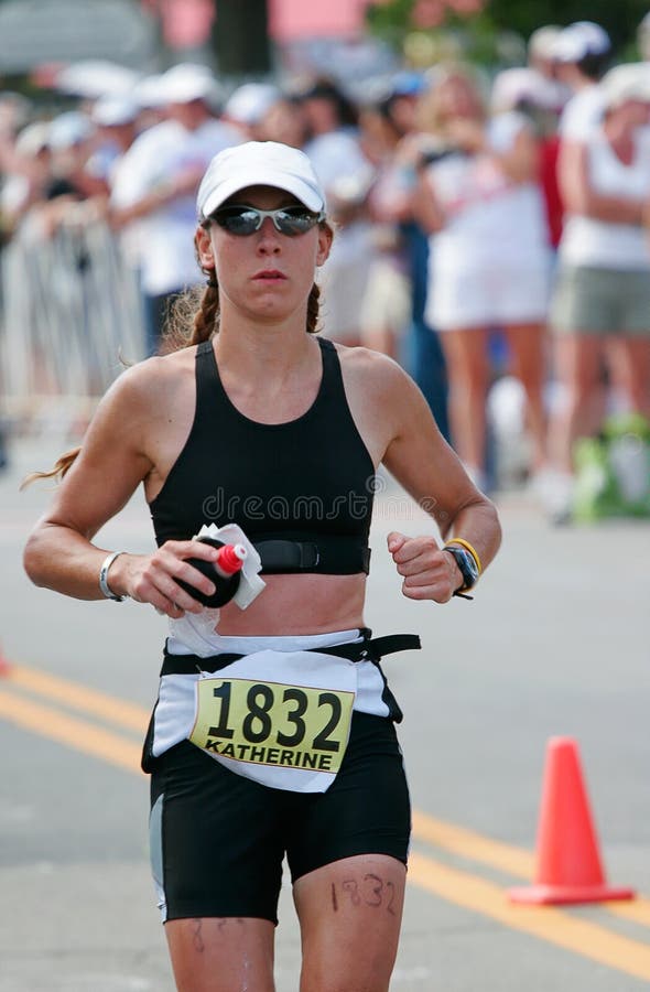 Triathlete female runner is on the last leg of an ironman running a marathon. Triathlete female runner is on the last leg of an ironman running a marathon.