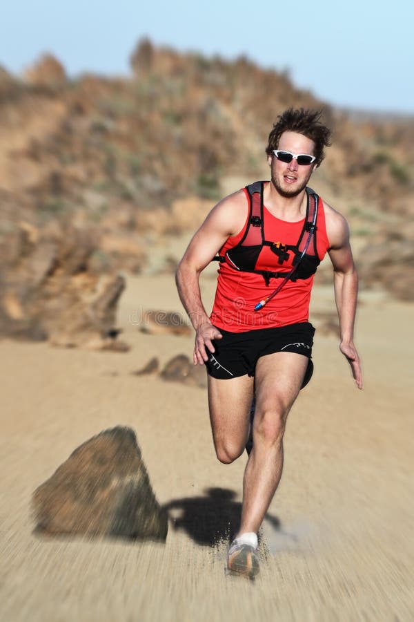 Runner. Man running fast in dramatic desert landscape. Fit fitness trail runner sprinting at high speed. Caucasian male model outside. Runner. Man running fast in dramatic desert landscape. Fit fitness trail runner sprinting at high speed. Caucasian male model outside.