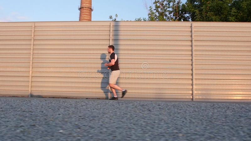 Corredor - homem do atleta running treinando fora o exercício na estrada da montanha Movimento lento