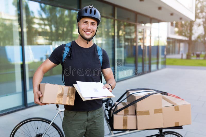 Correio da bicicleta que faz uma entrega foto de stock Correio da bicicleta que faz uma entrega foto de stock
